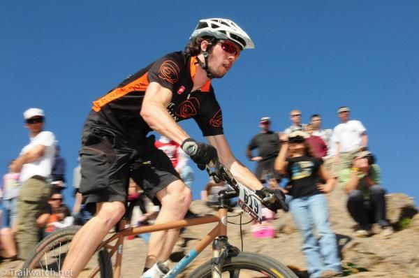 A racer checks out a technical descent ahead of him