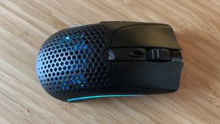 Glorious Model O 2 Mini Wireless gaming mouse with blue RGB lighting on a wooden desk