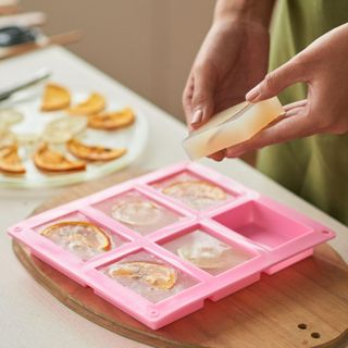 Woman taking soap bars out of plastic form alamy 2JK18Y7