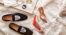 2 pairs of shoes, including a pair of high heels, available from Rue La La on a rug next to glasses of wine on a tray.