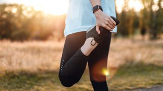 Young Woman Stretching Legs In The Park After Exercise