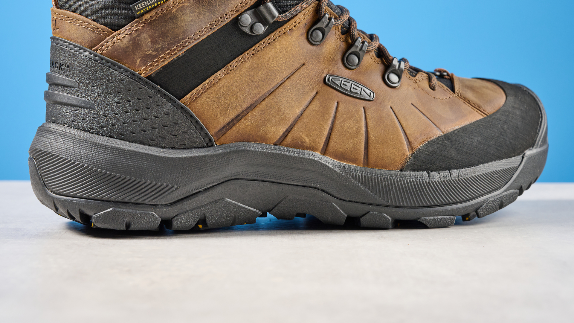 The Keen Revel IV outsole on a stone surface with a blue background