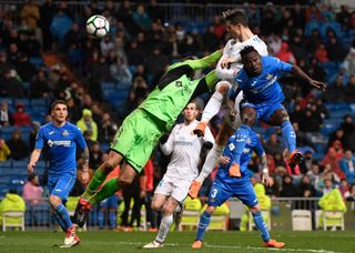 Cristiano Ronaldo (top) heads the ball to score a goal during the Spanish league football match Real Madrid CF against Getafe CF at the Santiago Bernabeu stadium in Madrid on March 3, 2018.