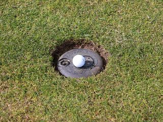 Golf ball resting on a sprinkler head