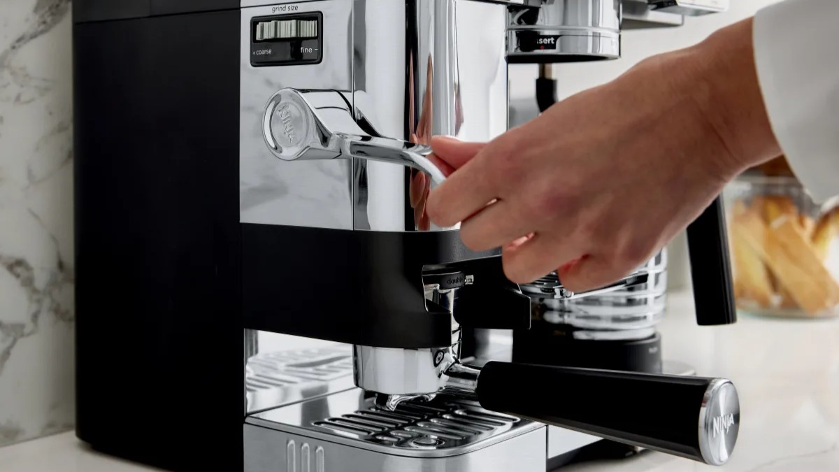 Person using tamper on Ninja Luxe Café Pro coffee machine
