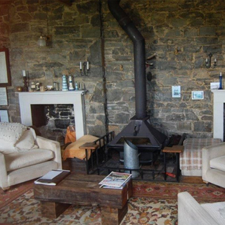 living room with stone wall chimney and sofa set