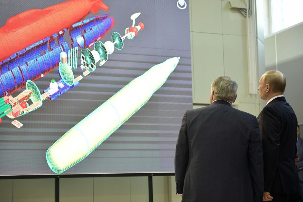 Russian President Vladimir Putin examines plans for a rocket