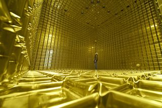 A view of a room with a close-up of the metallic grid material that covers the floors, wall, and ceiling