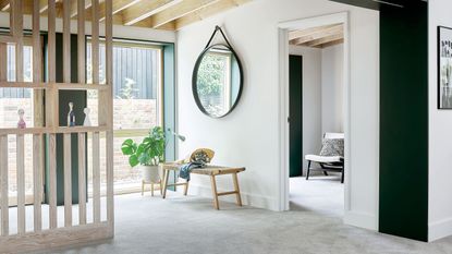 Grey carpet in white room with wooden beams