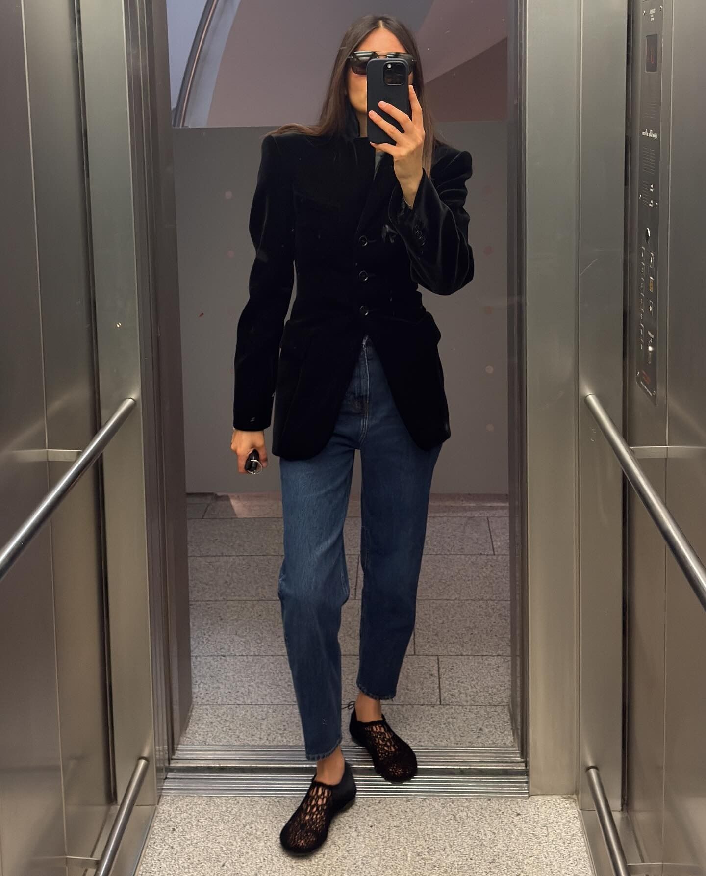 @majawyh wearing a black blazer, jeans, and black crochet flats.