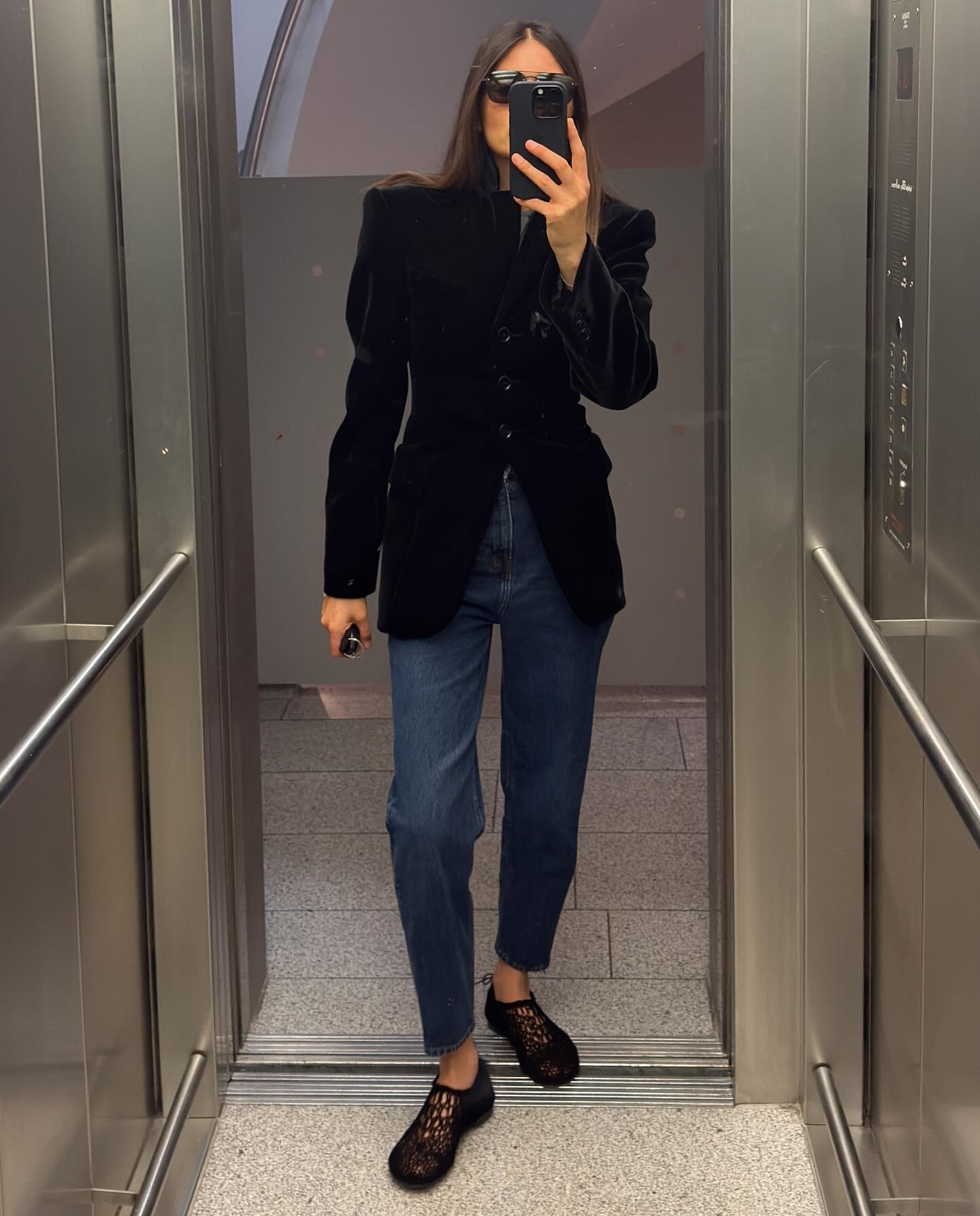@majawyh wearing a black blazer, jeans, and black crochet flats.