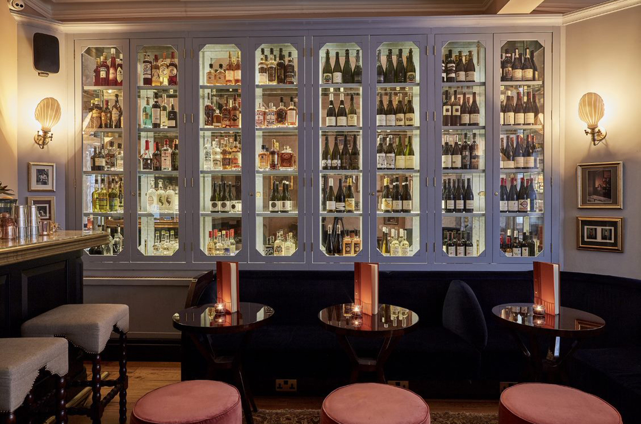 The Mulwray wine bar with tables and chairs and a wine wall