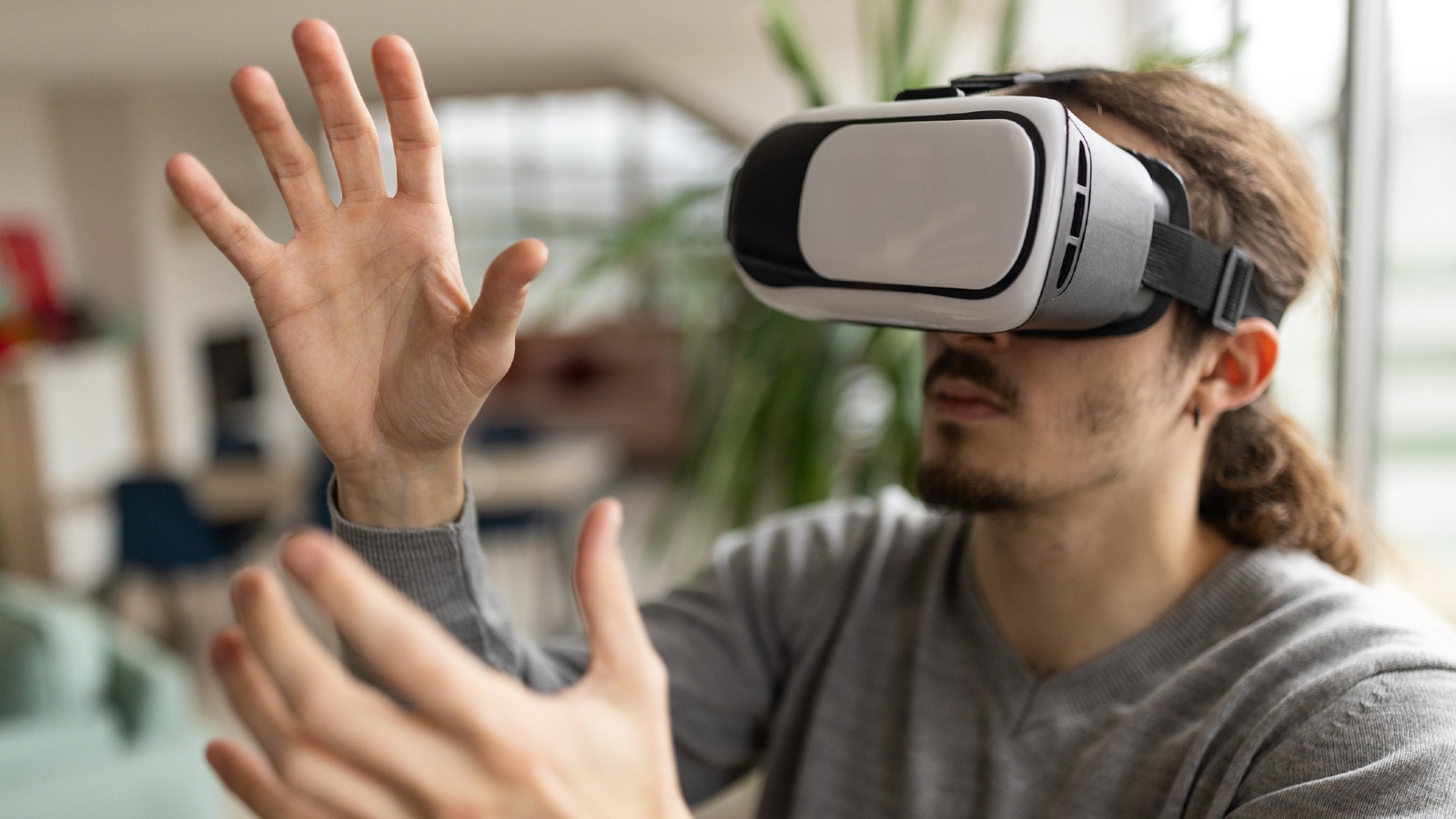 A man plays a virtual reality game while wearing a headset
