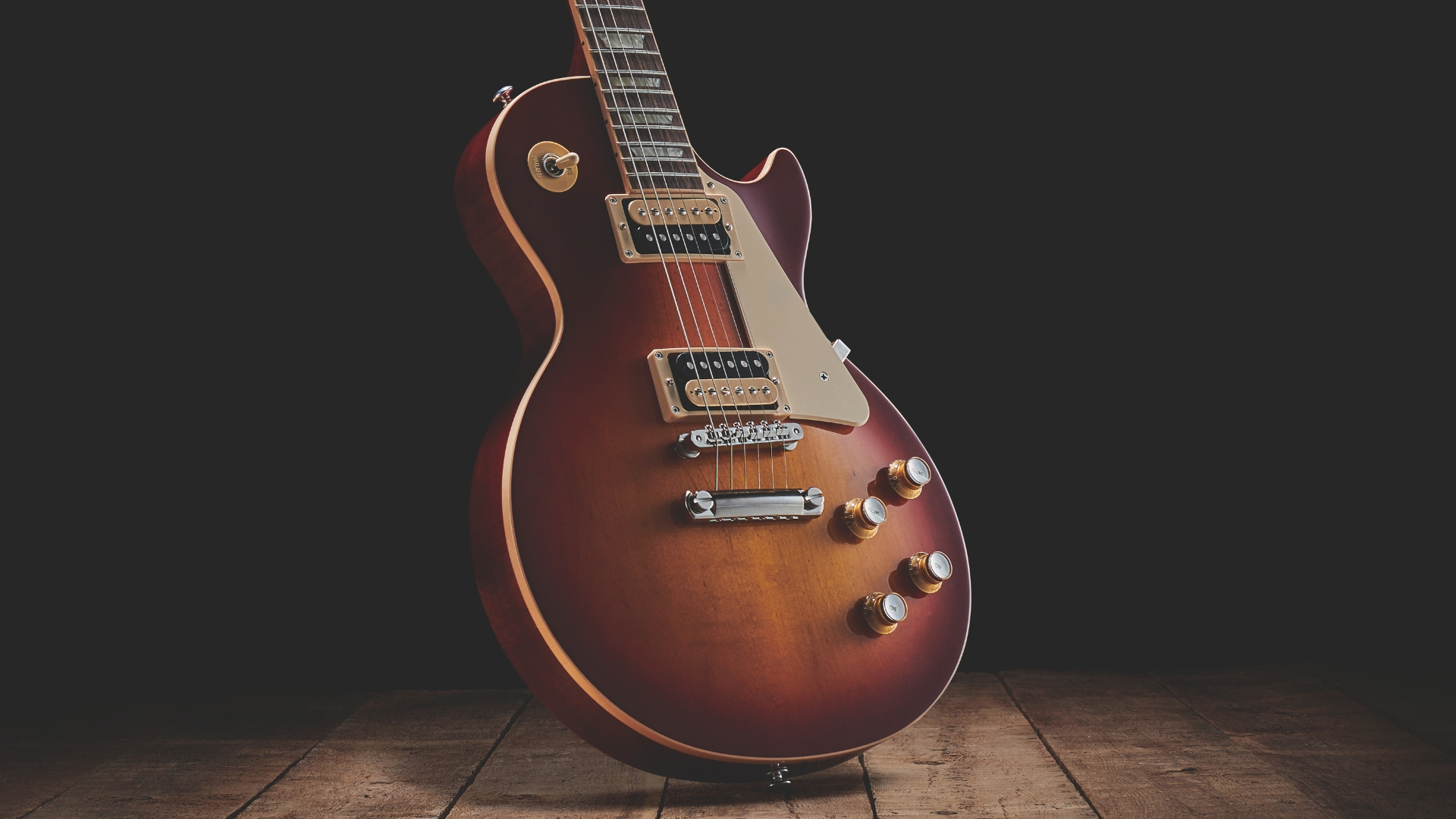 A Gibson Les Paul Standard 60s electric guitar in dark room on a wooden floor