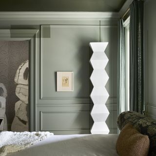 a sage green wall in a bedroom