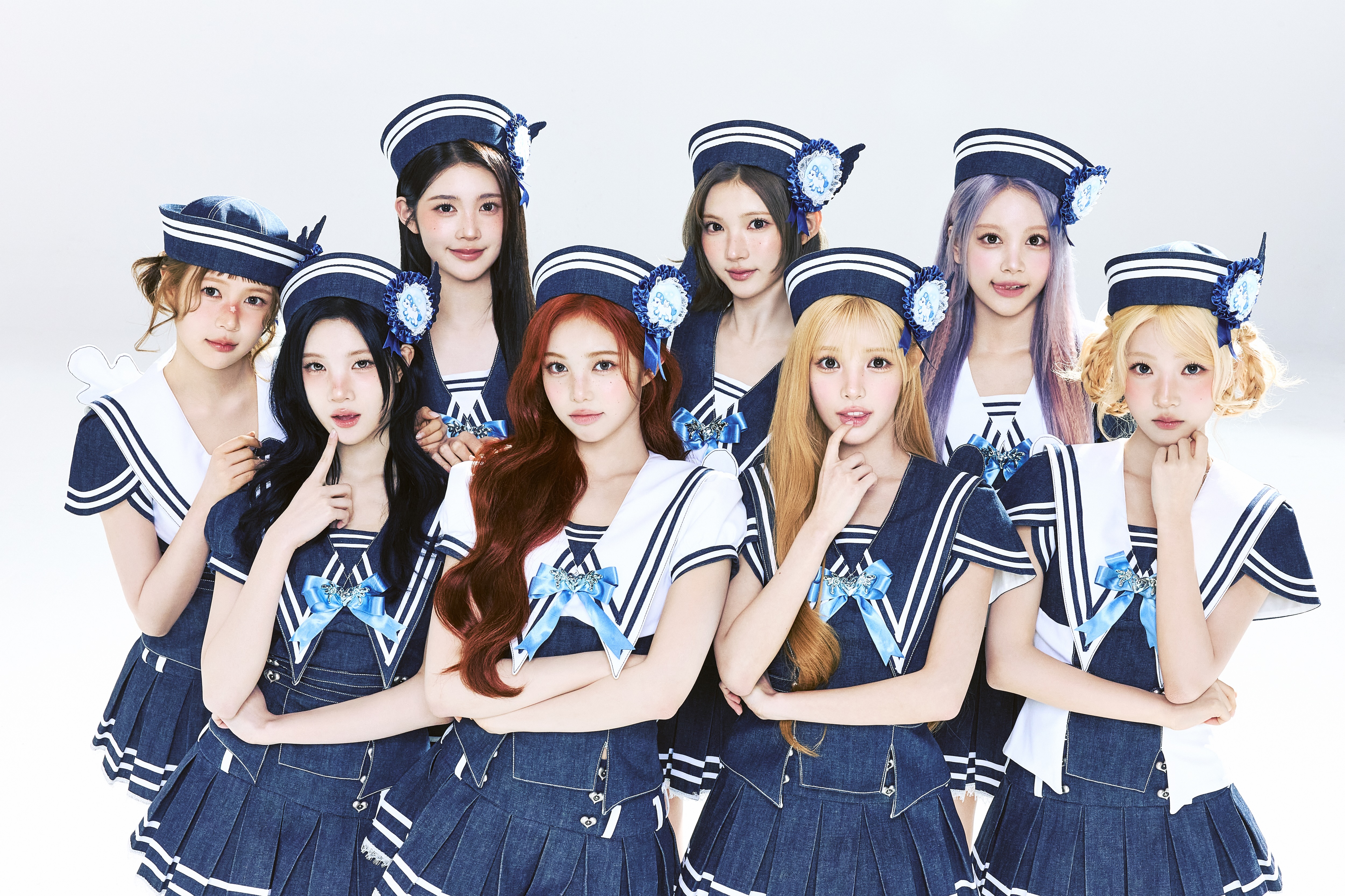 The members of K-pop group Hearts2Hearts (l-r Ye-on, Juun, A-na, Ian, Stella, Yuha, Carmen, and Jiwoo) wear sailor outfits while posing in front of a white background.