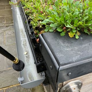 Worx pressure washer being tested on a gutter