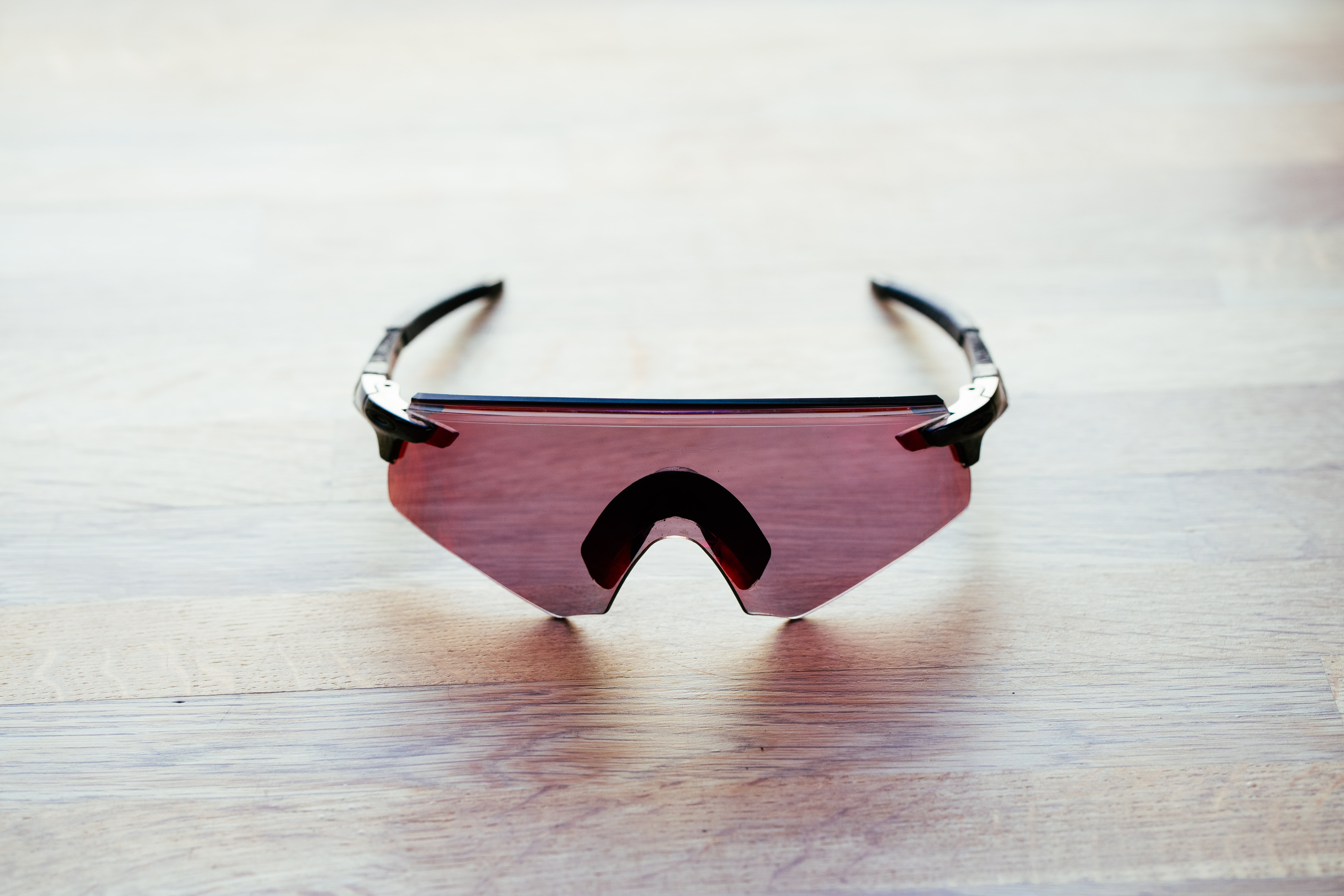 A set of frameless cycling glasses on a wooden surface