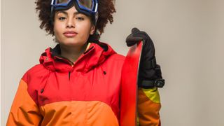 Woman wearing jacket holding snowboard