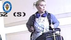 A CCTV still of Aimee Betro with a backpack and a wheelie suitcase
