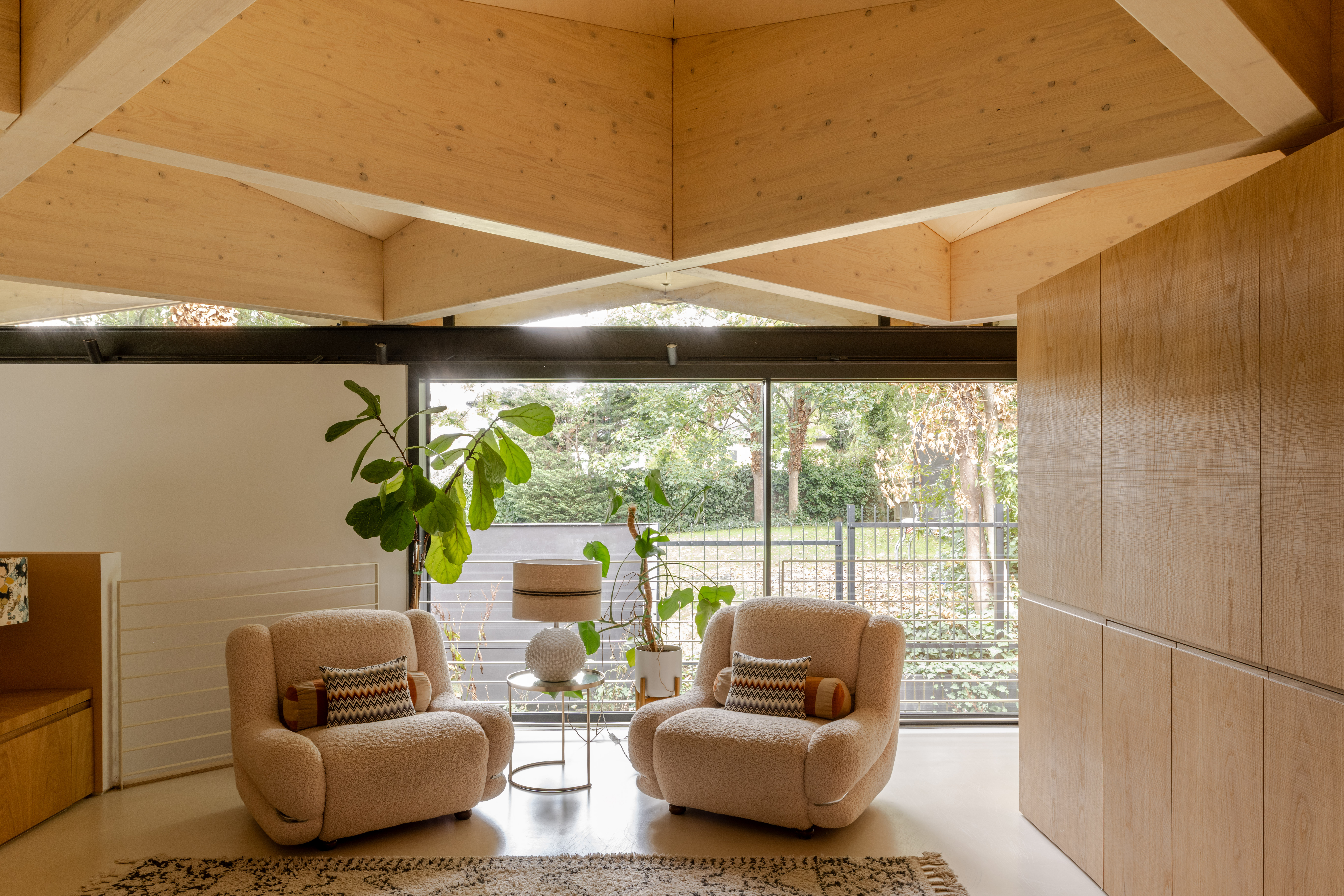 arbour house, a low, one storey home in a back year among trees, but with a distinctive angular roof
