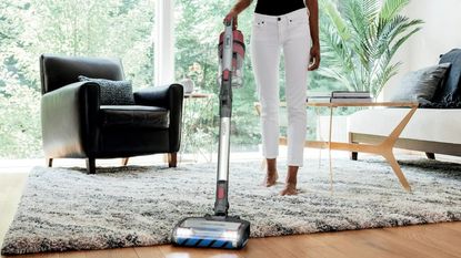 One of the best cordless vacuum cleaners, the Shark Vertex, cleaning a rug and a wood floor