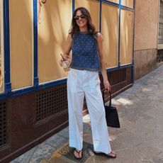 Kim wearing white trousers and blue top