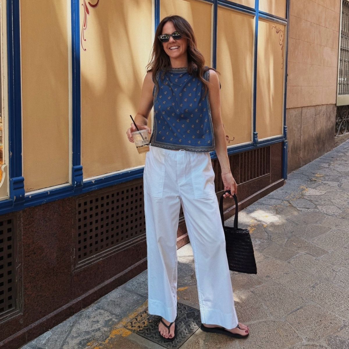 Kim wearing white trousers and blue top