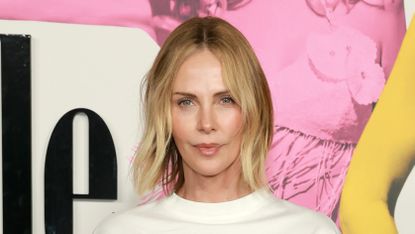 Charlize Theron wearing pinstriped trousers and an oversized tee