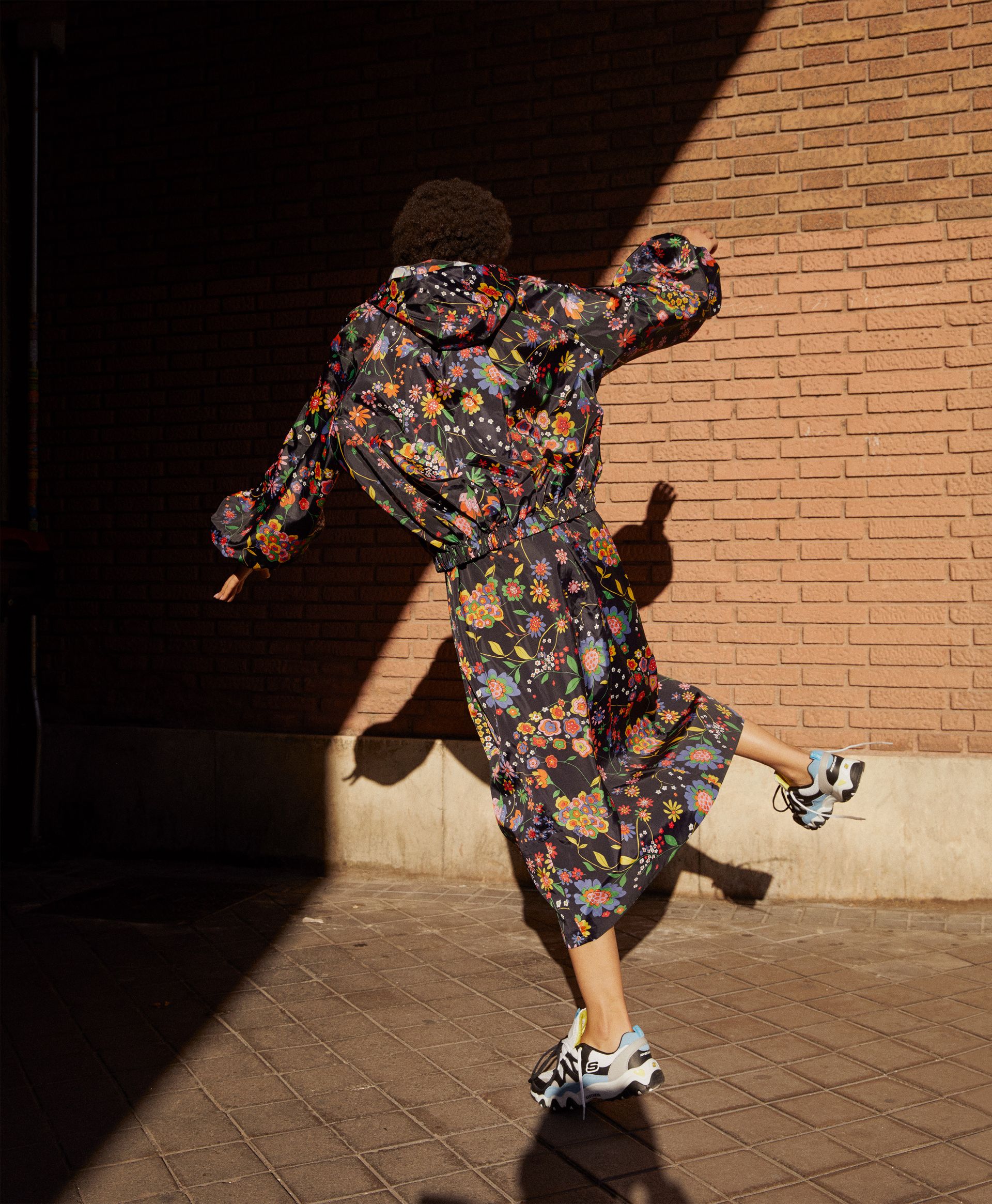 woman in floral rain jacket and sneakers