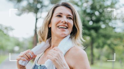 Woman smiling and laughing, holding sweat towel around shoulders and wearing a fitness tracker, representing what happens when you stop drinking alcohol for a month