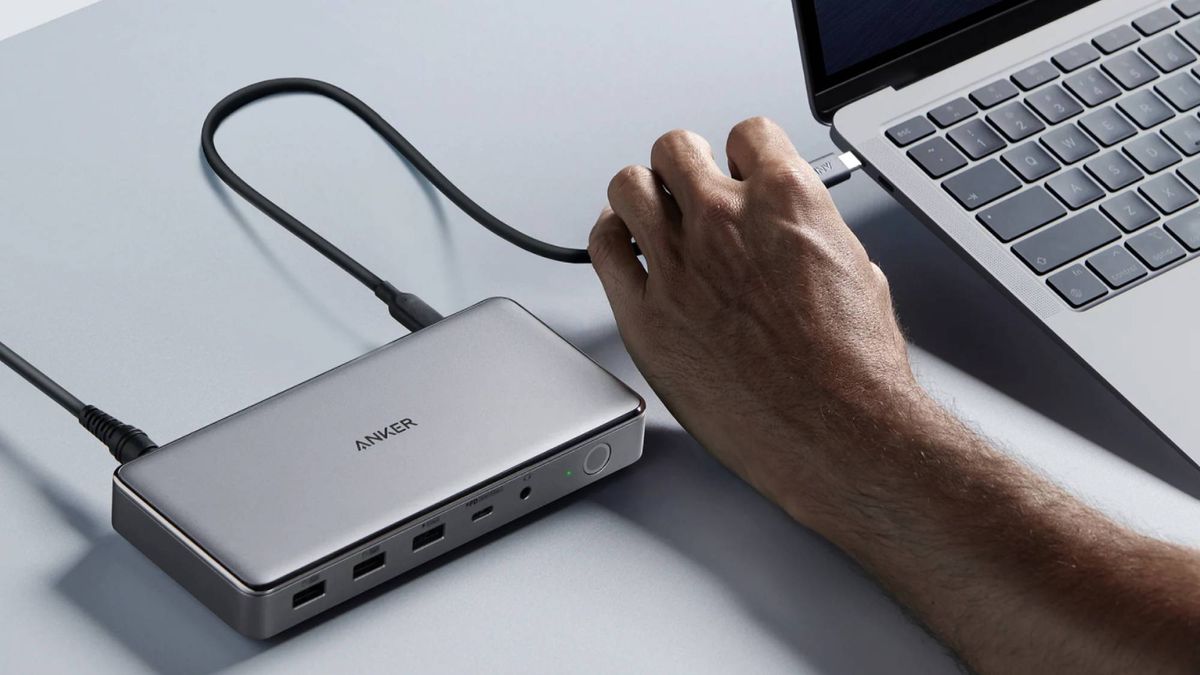 Man connecting Anker 563 docking station to a MacBook 