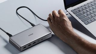 Man connecting Anker 563 docking station to a MacBook