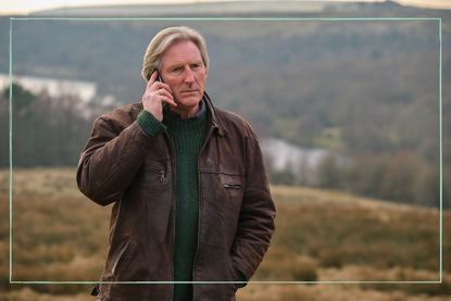 Adrian Dunbar on the phone stood on a hill top in ITV drama Ridley 
