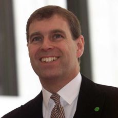 Prince Andrew wearing a suit and tie smiling in 2000
