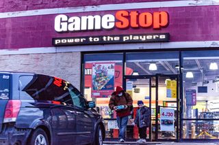 Man and child wearing face masks leave GameStop store in Athens, Ohio.
