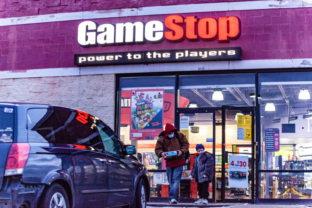 Un homme et un enfant portant des masques faciaux quittent le magasin Gamestop à Athènes, Ohio.