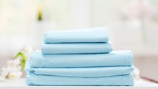 A stack of folded blue bedsheets 