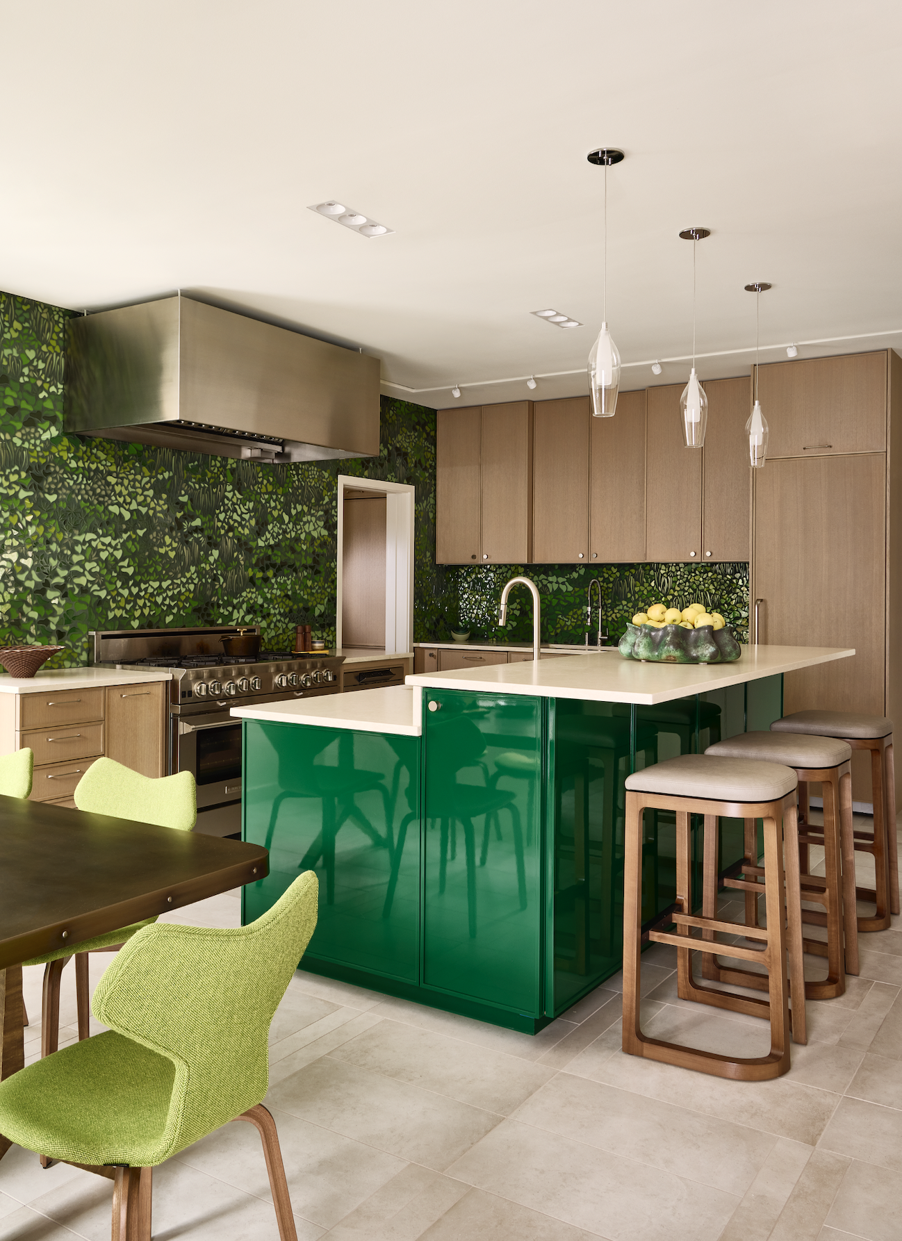 A kitchen with emerald green island, and a wallpaper in a similar shade