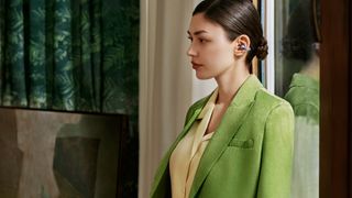 Huawei FreeClip earbuds worn by woman in green jacket