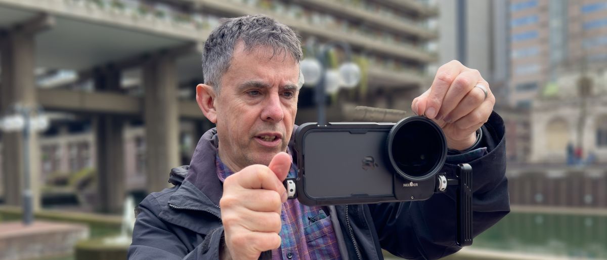 NEEWER PA024K Cage for iPhone 15 Pro Max held in the hands of DCW reviewer George Cairns