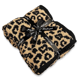 A black and tan leopard print fuzzy throw blanket
