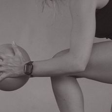 A woman holding a Pilates ball during a workout