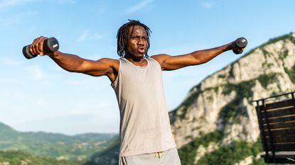 Man training with dumbbells outside