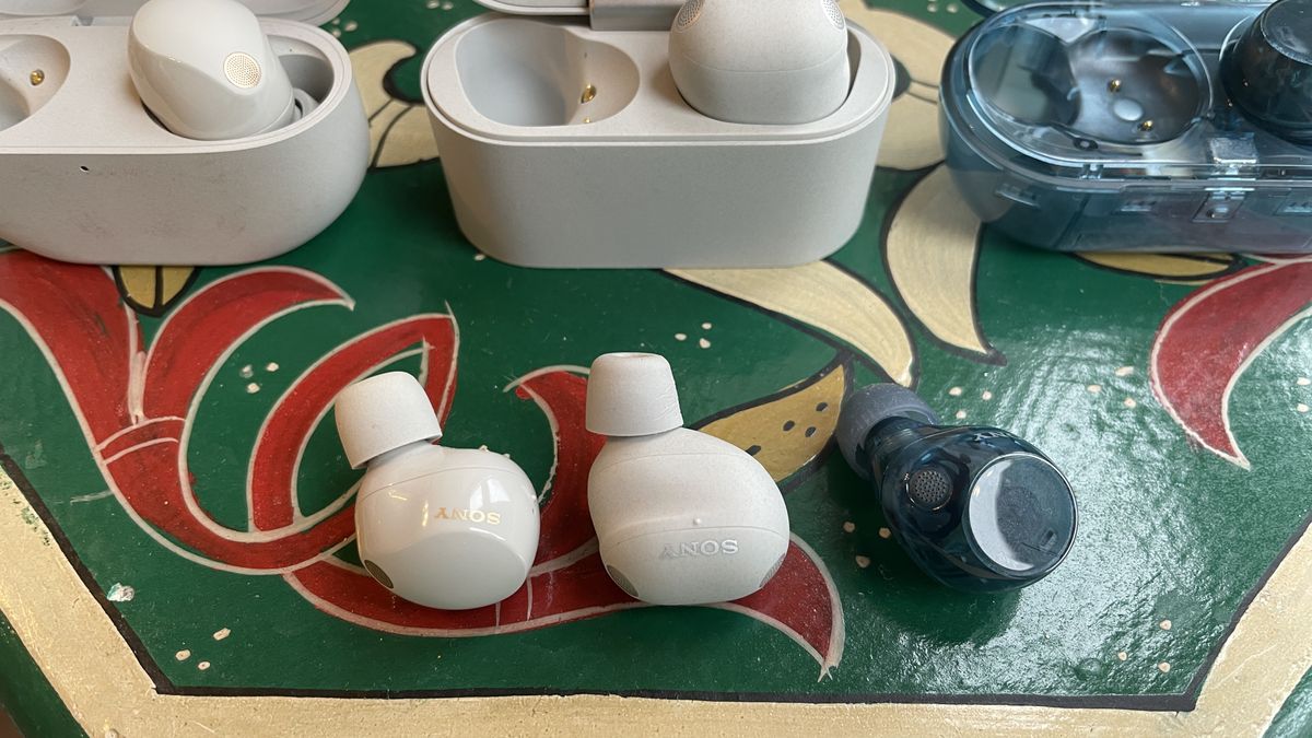 Sony WF-1000XM6 earbuds next to the older-gen. WF-1000XM5 and WF-C710N, on colorful table