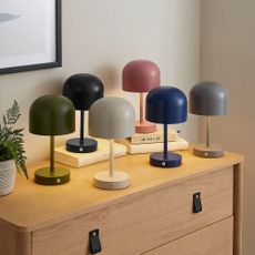 lots of Dunelm wireless rechargeable lamps in various colours on a sideboard