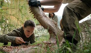 Annihilation Natalie Portman Tessa Thompson examining an alligator in the jungle