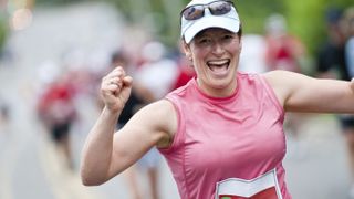 Happy woman finishing mass participation running race