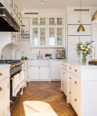 Floor-to-ceiling kitchen storage in white kitchen with wood floors