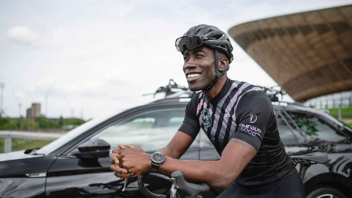 a black man outside a ŠKODA in cycling kit